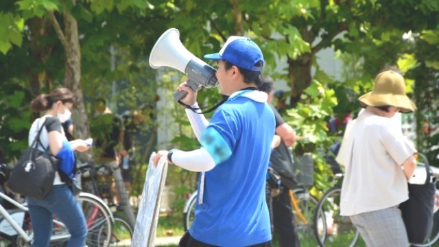 看板でお店のアピールをする人